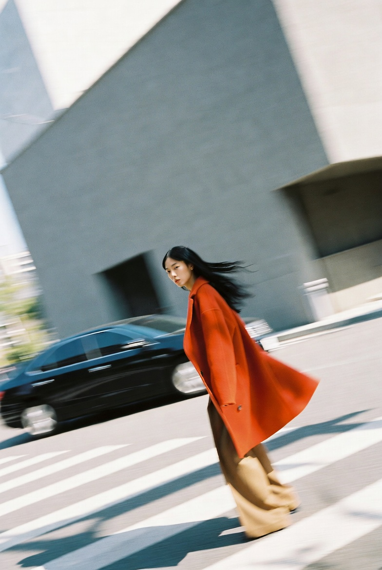 Woman in a Burnt Orange Coat at an Autumn Crosswalk