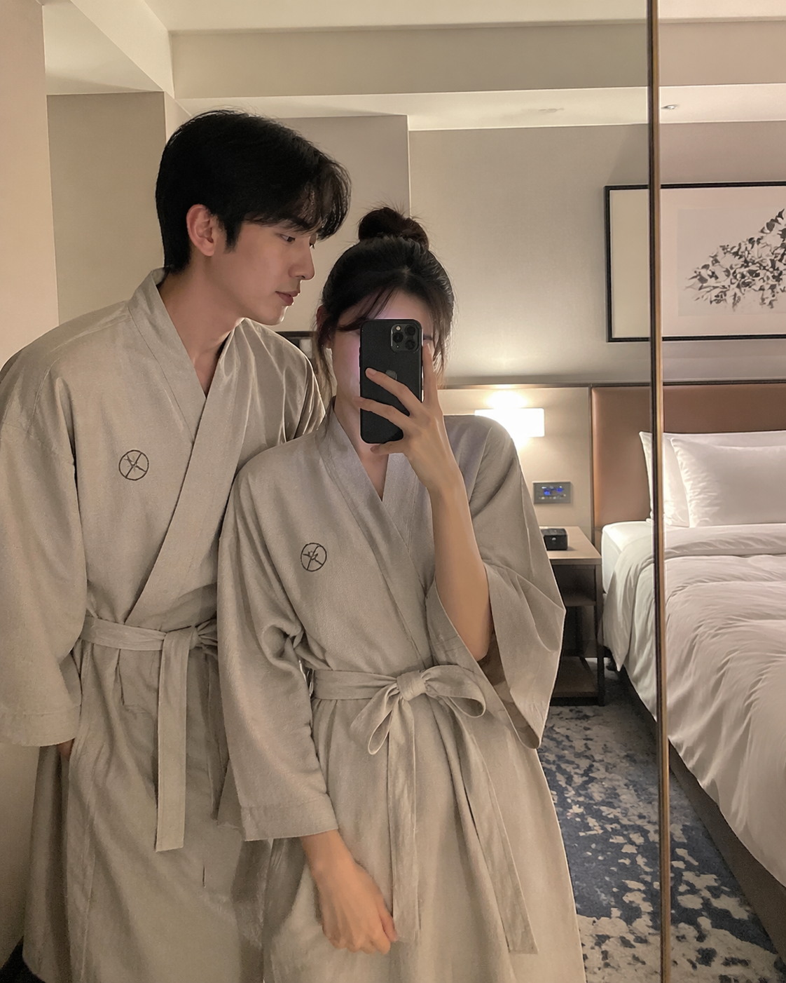 Pareja en yukata tomándose un selfi frente al espejo del hotel