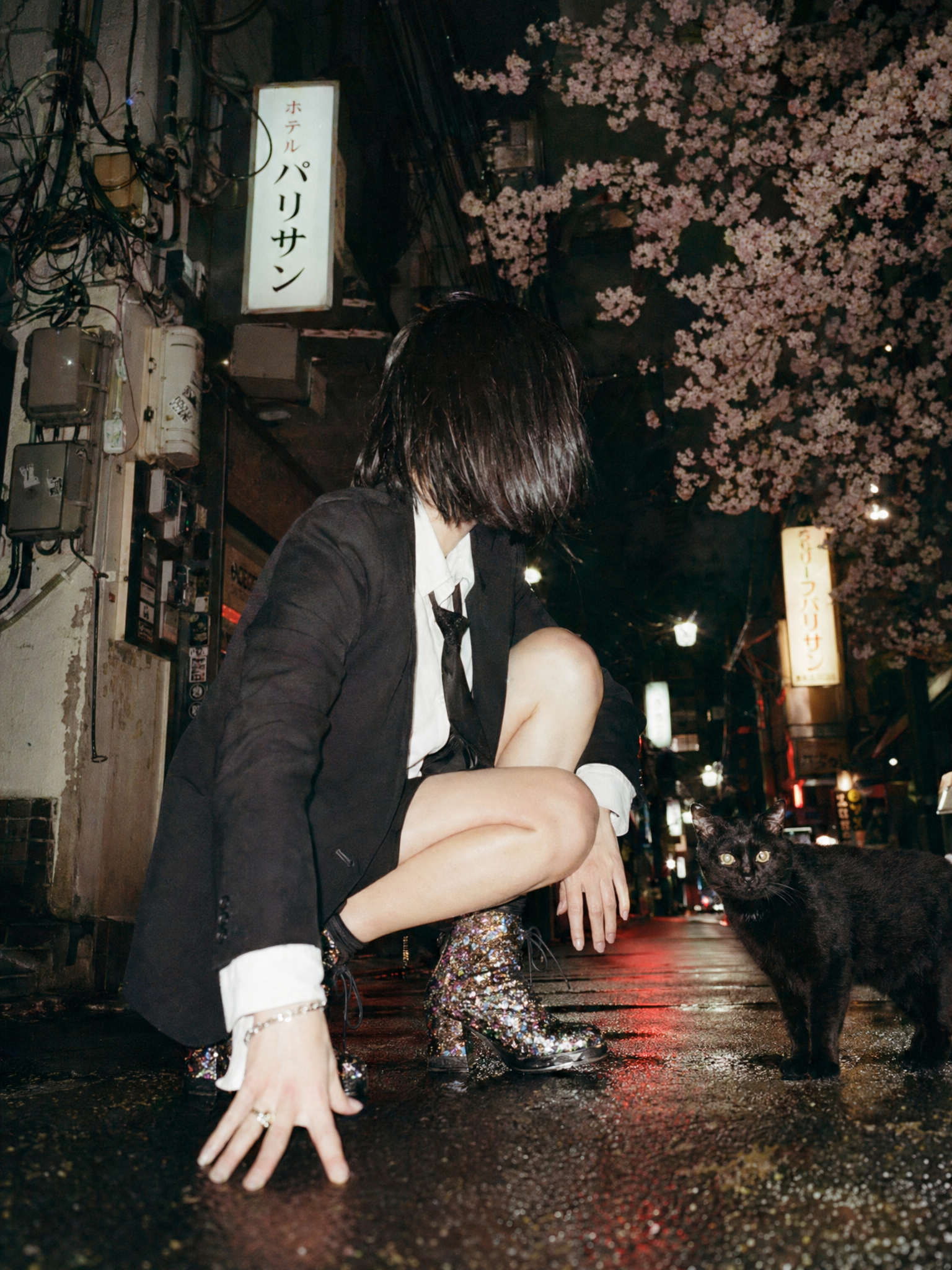 Black Cat and Crouching Figure in Rainy Tokyo