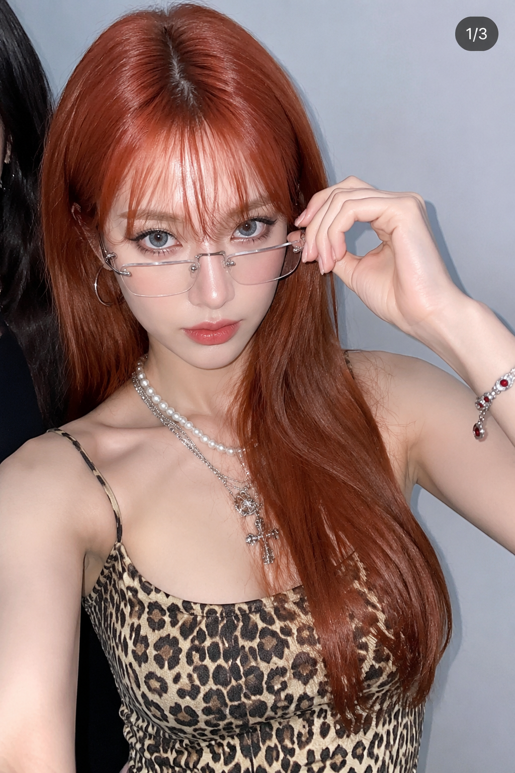 Femme aux cheveux cuivrés ajustant ses lunettes