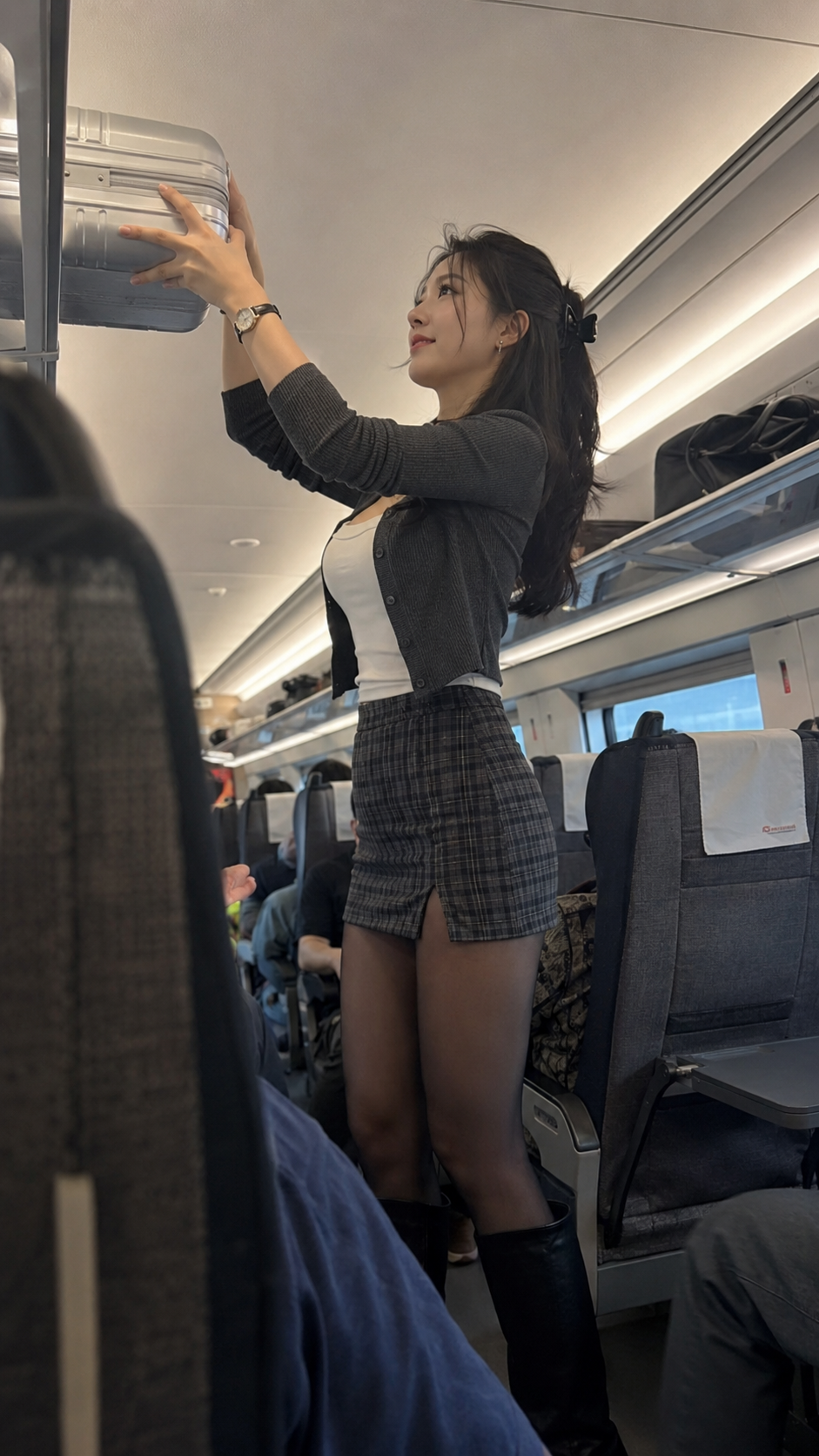 Woman Lifting a Silver Suitcase on a High-Speed Train